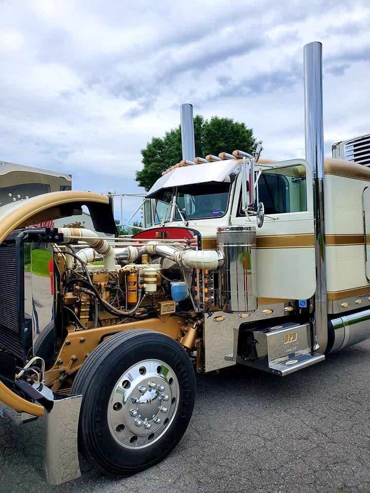 photo of gold trimmed big rig truck cab with exposed engine