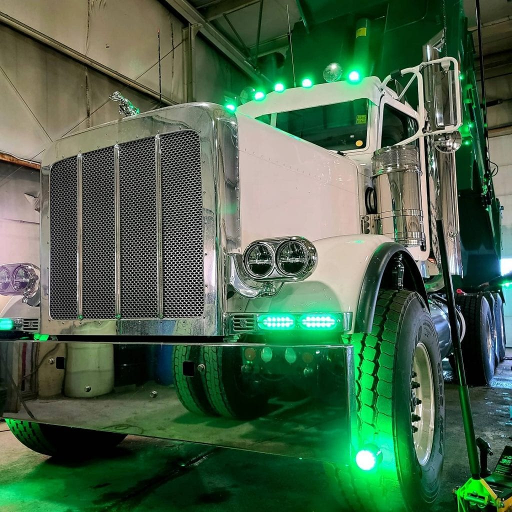 photo of big rig truck in garage with green lights